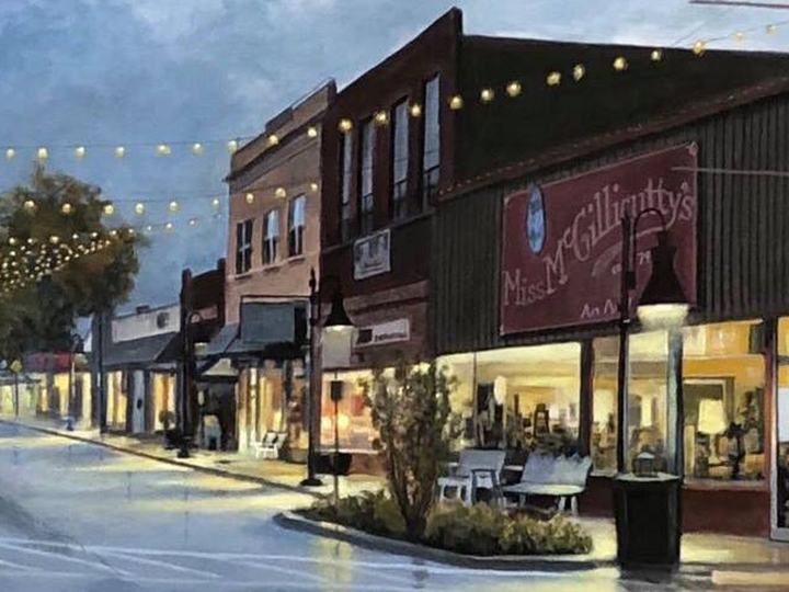 Shops and string lights along Main Street in Jenks at dusk