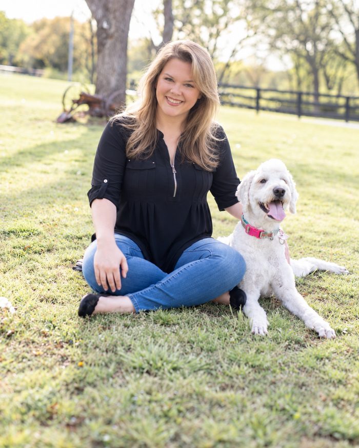 Morgan Tipton sitting in the grass with her dog Bubbles